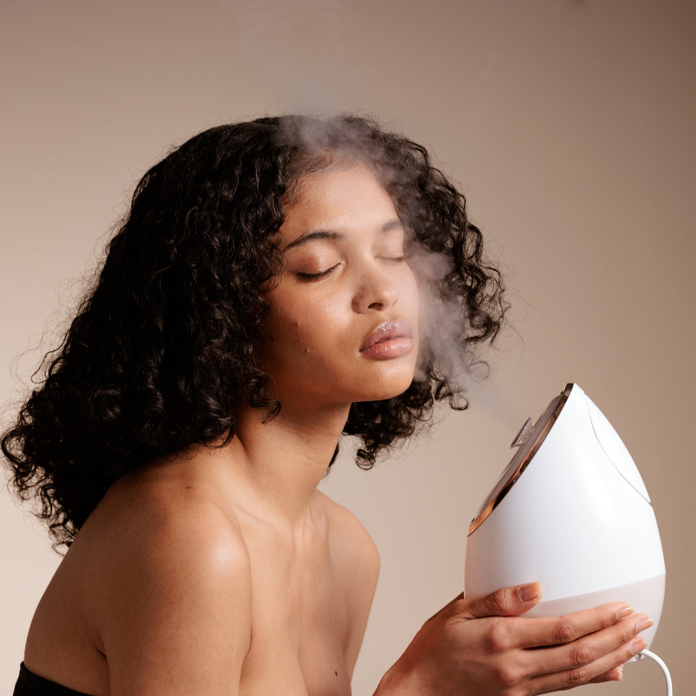 Woman preparing skin with Sensa nano ionic facial steamer.