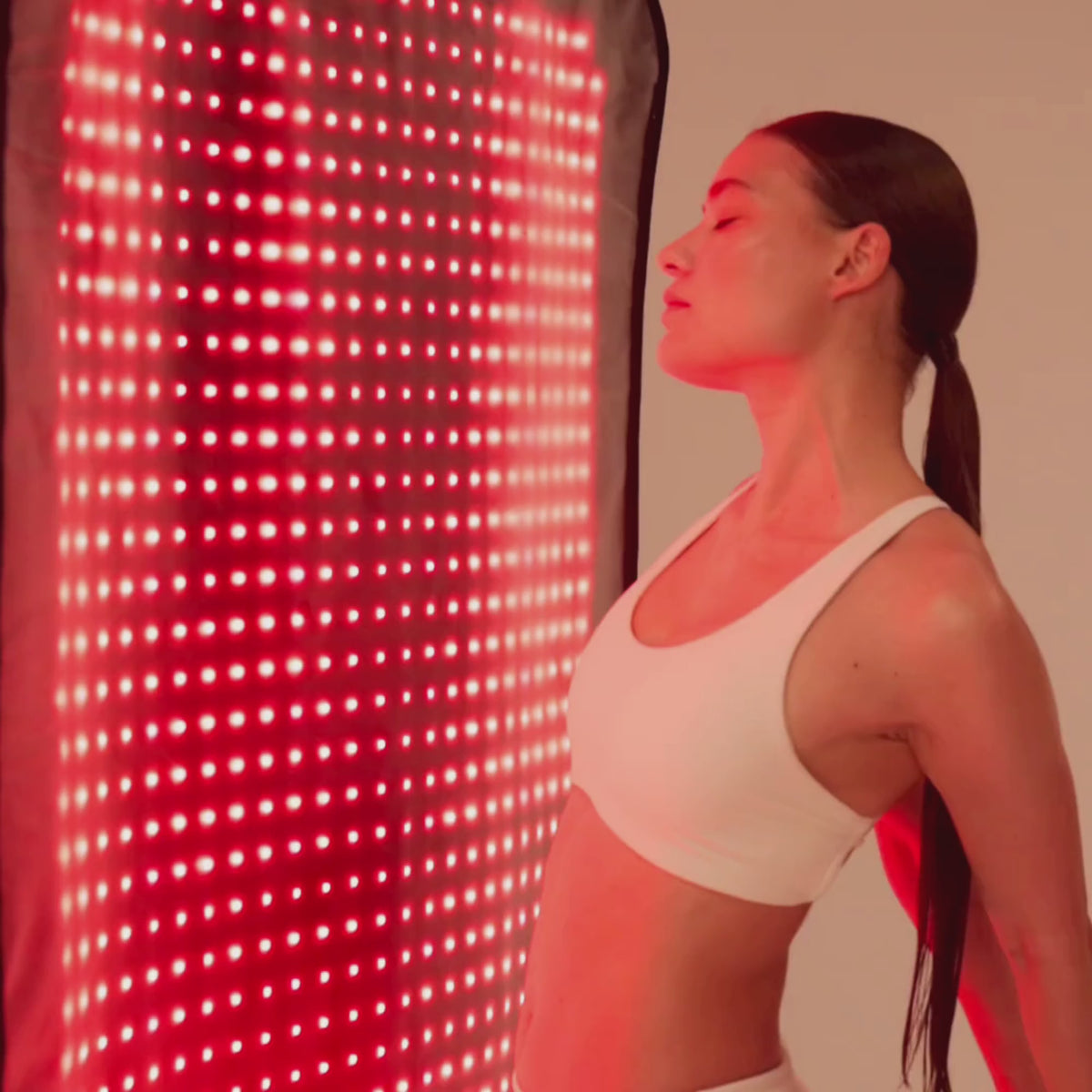 Video: woman using the Restora LED mat while it hangs vertically and while lying on it